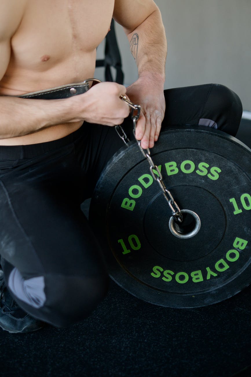 man putting a chain on a weight